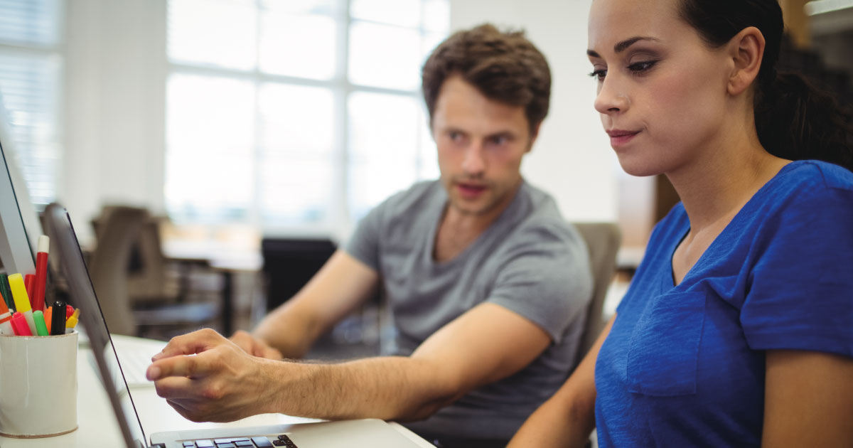 Kollegen diskutieren über einen Laptop